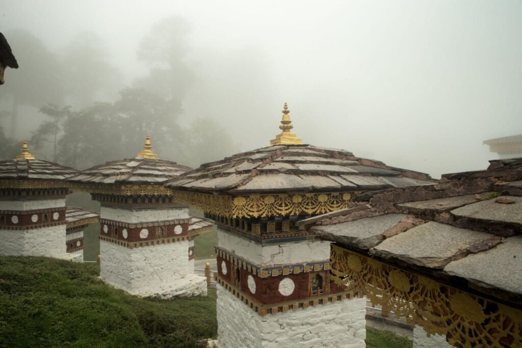bhutanese monuments in mountain fog with seven sands tourism