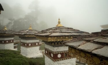 bhutanese monuments in mountain fog with seven sands tourism