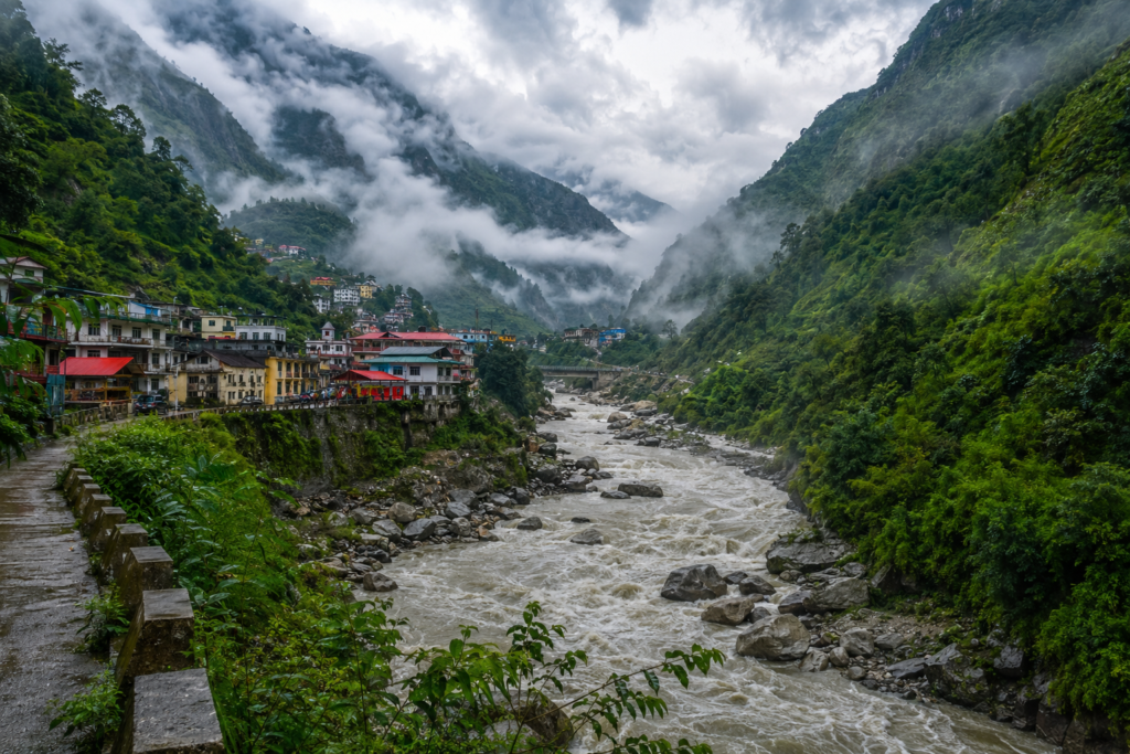 The fast-flowing Mandakini River valley surrounded by lush green mountains during the monsoon season near Sonprayag route